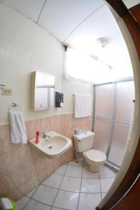 a bathroom with a toilet and a sink at Hotel Posada Don Pantaleon in Managua