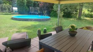 a wooden table with chairs and a pool in a yard at Pension Rainbow*** in Karlovy Vary
