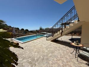 a swimming pool with a staircase next to a house at Sun Thavma Living studio psiloritis in Lístaros +34 photos