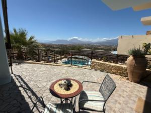 a patio with a table and chairs and a pool at Sun Thavma Living studio psiloritis in Lístaros