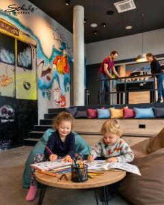 two young children sitting at a table in a room at Schulz Hotel Berlin Wall at the East Side Gallery in Berlin