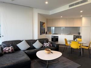 a living room with a couch and a table at Newcastle Beach Escape in Newcastle