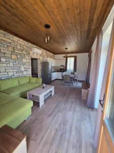 a living room with a green couch and a table at Alyki Stone House 2 in Alyki +6 photos