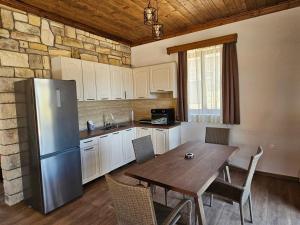 a kitchen with a wooden table and a refrigerator at Alyki Stone House 2 in Alyki