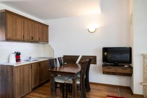a kitchen with a wooden table and a tv at Студио in Starosel