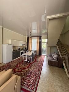 a living room with a table and a kitchen at HOTEL Vzmorye in Bosteri