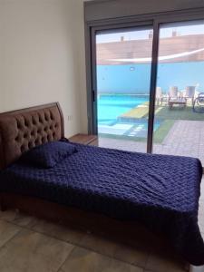 a bed in a bedroom with a view of a pool at شاليهات الشهد والحلا in Amman