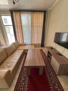 a living room with a couch and a flat screen tv at HOTEL Vzmorye in Bosteri