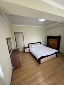 a bedroom with a large bed and a wooden floor at HOTEL Vzmorye in Bosteri