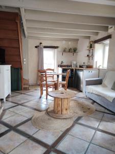 a living room with a table and a kitchen at La maison d'André in Laurière