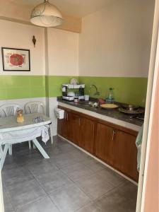 a kitchen with green and white walls and a table at Atlas Nest in Beni Mellal