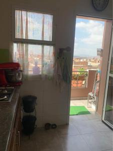 a kitchen with a door open to a balcony at Atlas Nest in Beni Mellal