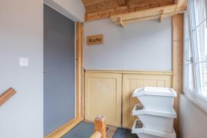 a bathroom with a toilet and a barn door at Buche in Interlaken +12 photos