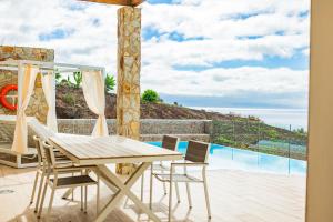 a patio with a table and chairs and a view of the ocean at Playitas Hotel - Sports Resort in Las Playitas