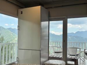 a refrigerator on a balcony with a table and chairs at Casa Azul Mountain Resort in Nathia Gali +17 photos