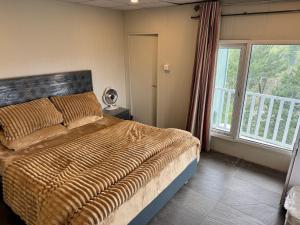 a bedroom with a bed and a large window at Casa Azul Mountain Resort in Nathia Gali