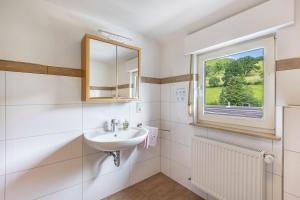 a white bathroom with a sink and a window at Ferienhof Pohl-Optimal für Familien in Lennestadt +83 photos