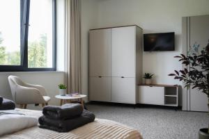 a bedroom with a bed and a white cabinet at Willa na wyłączność z jacuzzi - Willa Natura Anastazewo in Szydłowiec