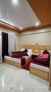 two beds sitting in a room with at Jai Shri Badri in Badrinath