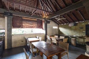a dining room with tables and chairs and a window at Taman Ayu Legian Hotel in Legian