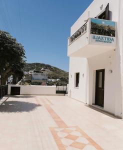 a white building with a sign on the side of it at Iliaxtida apartments II in Grámousa +2 photos