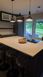 a kitchen with a table with a bowl of fruit on it at Modern cosy house with forest views in Södertälje