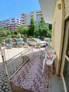 a balcony with a table and chairs and a fence at Proper Apartment in Vlorë