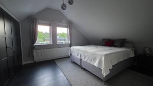 a bedroom with a white bed and a window at Modern cosy house with forest views in Södertälje
