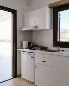 a white kitchen with a sink and a dishwasher at Iliaxtida apartments II in Grámousa