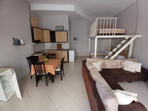a living room with a couch and a table and a kitchen at Proper Apartment in Vlorë