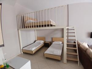 a small room with two bunk beds and a ladder at Proper Apartment in Vlorë