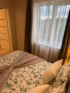 a bedroom with a bed and a window at ESSE Apartament in Gulbene