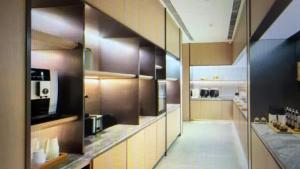 a large kitchen with wooden cabinets and a kitchenasteryasteryasteryasteryasteryasteryastery at JI Hotel Beijing Huilongguan in Changping