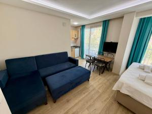 a living room with a couch and a bed and a table at Arti̇m Apart Hotel in Fethiye