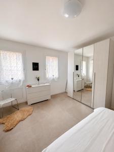 a white room with a bed and a mirror at Appartamento Sofia in Sossano