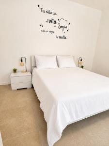 a bedroom with a large white bed with words on the wall at Appartamento Sofia in Sossano