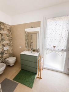a bathroom with a sink and a toilet and a window at Appartamento Sofia in Sossano +16 photos