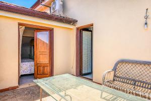 a patio with a bench and a door and a bed at Casa Vacanze Panoramics in Acquedolci