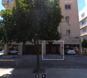 a tree in front of a building with a mirror at Spacious Central Nicosia Flat - Quiet & SafeArea in Nicosia