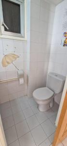 a white bathroom with a toilet and a window at Spacious Central Nicosia Flat - Quiet & SafeArea in Nicosia