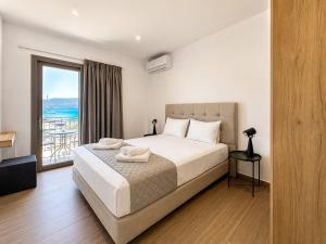 a bedroom with a bed with a view of the ocean at Dolphin hotel in Korfos +22 photos