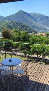 a table and chairs on a deck with a view of mountains at Zois Apartment in Gliki