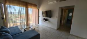 a living room with a couch and a large window at Zois Apartment in Gliki
