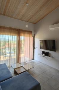 a living room with a blue couch and a tv at Zois Apartment in Gliki