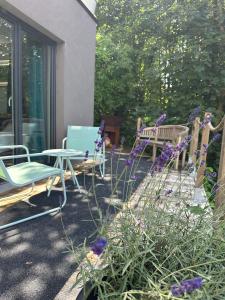 a patio with chairs and a table and purple flowers at Meuse Cottage in Hastière-par-delà +69 photos