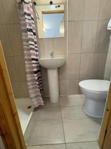 a bathroom with a sink and a toilet and a mirror at Seven Dials Hotel in London
