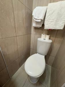 a white toilet in a bathroom with towels at Seven Dials Hotel in London
