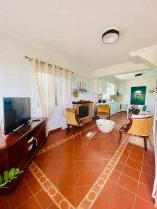 a living room with a tiled floor and a television at Maison See View in Kontokali