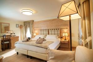 a bedroom with a bed and a desk and a lamp at Hotel Edelweiss 3 Stelle SUPERIOR in Breuil-Cervinia +92 photos