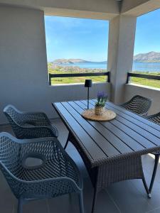 a wooden table and chairs in a room with windows at Nelany in Zubovići